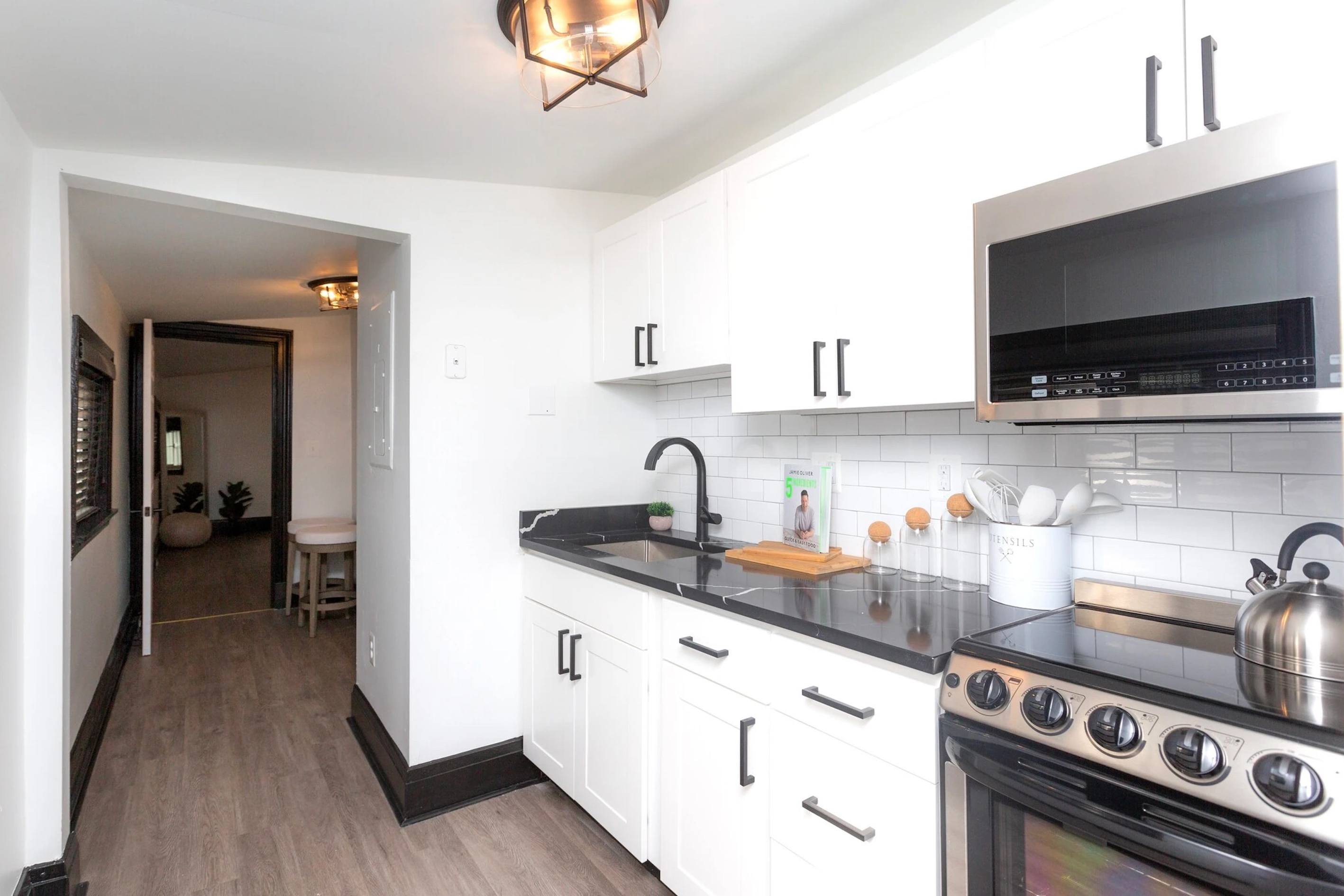 A kitchen with white cabinets and a black stove top.